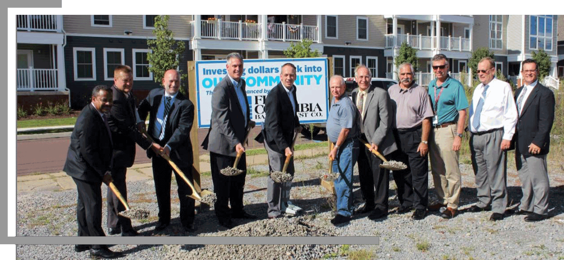 Multiple men lifting shovels full of concrete